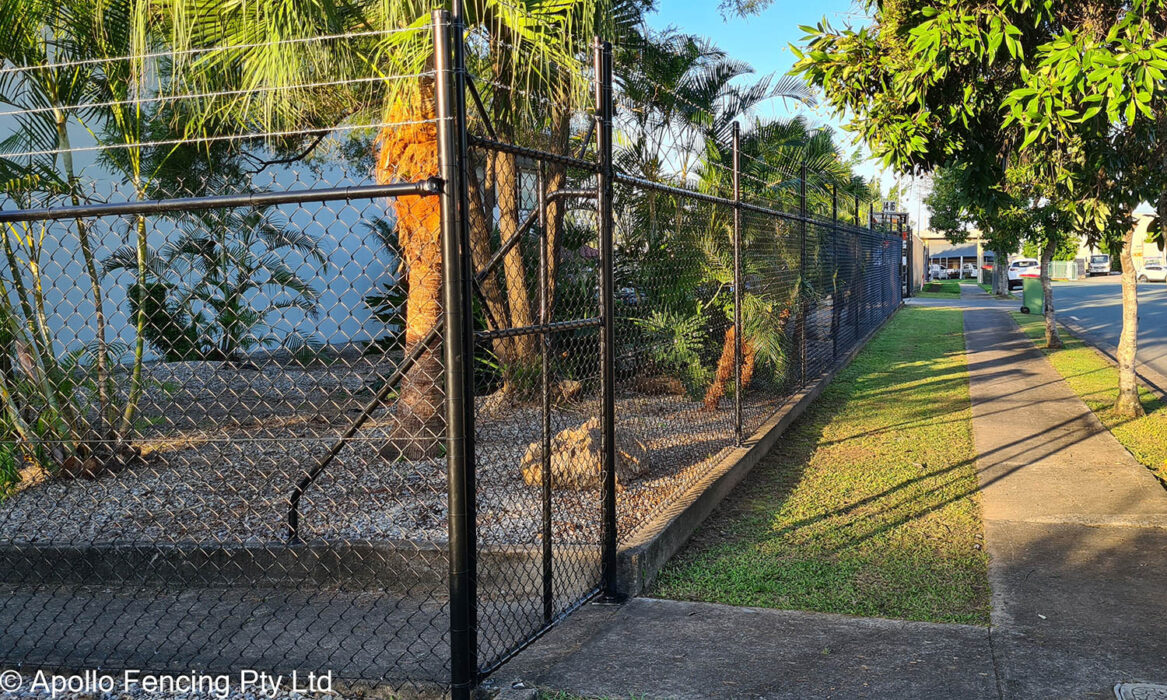 Black chain wire fence enclosing a landscaped property edge by Apollo Fencing Brisbane.
