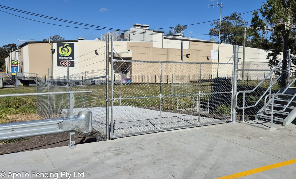 Galvanised chain-link security fencing with barbed wire top barrier, located in Ormeau, Gold Coast. Reinforces pedestrian access points and perimeter safety for commercial properties.