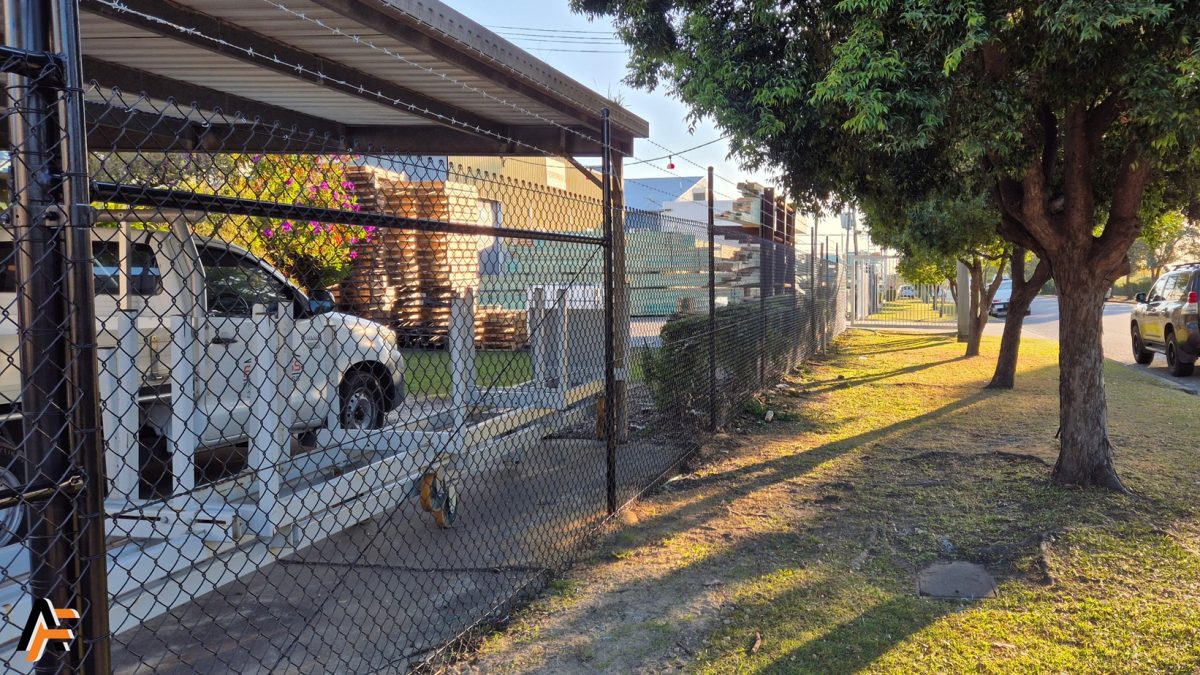 Commercial-grade chain wire fencing with barbed wire extension, reinforcing site security along the Gold Coast industrial precinct.
