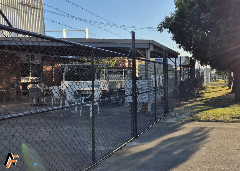 Chain wire security fencing with barbed wire protecting a workshop yard on the Gold Coast, designed for boundary security and controlled access.