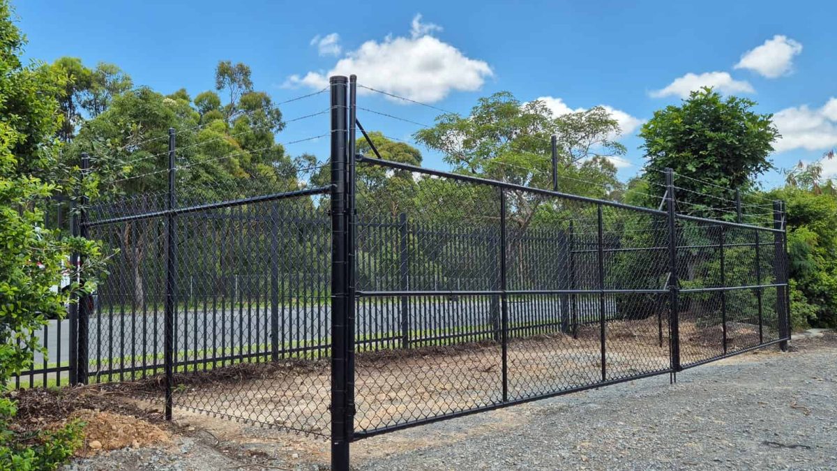 Black PVC coated chain wire fencing with gate installed at Yatala Queensland as a storage location installed by Apollo Fencing